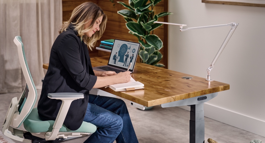 Person working at UPLIFT standing desk in focused, organized workspace